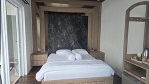 A modern bedroom with a large bed, wooden headboard, and a marble accent wall. - Probosiwi Resort (Nanggulan)
