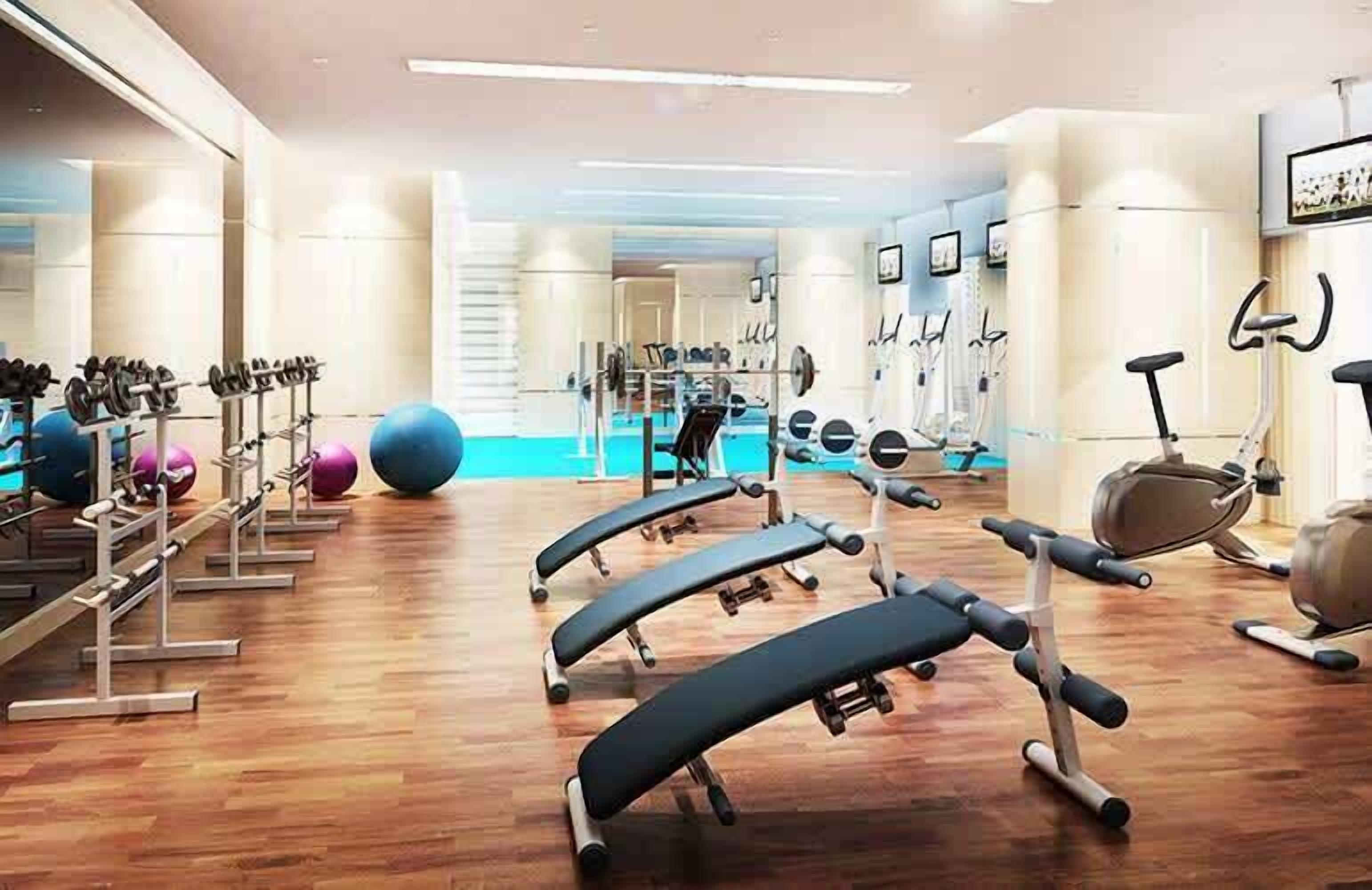 Une salle de sport équipée de matériel d’exercice, avec un ballon d’exercice bleu et un banc de musculation.