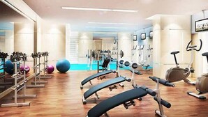 A gym with exercise equipment, a blue exercise ball, and a weight bench. - Stylish cozy studio in the heart of Business Bay (Dubai)