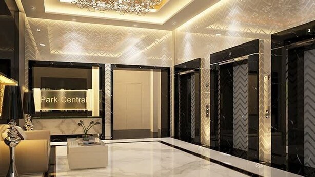 A modern lobby with a reception desk, a chandelier, and a sign for 'Park Central'. - Stylish cozy studio in the heart of Business Bay (Dubai)