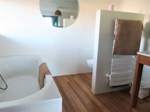 A bathroom with a bathtub, a toilet, and a mirror. - Beachfront house in Trébeurden with garden and terrace (Trébeurden)