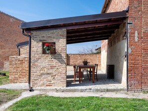 A brick building with a stone wall and a metal roof. - Barba Pipin by Interhome (Penango)