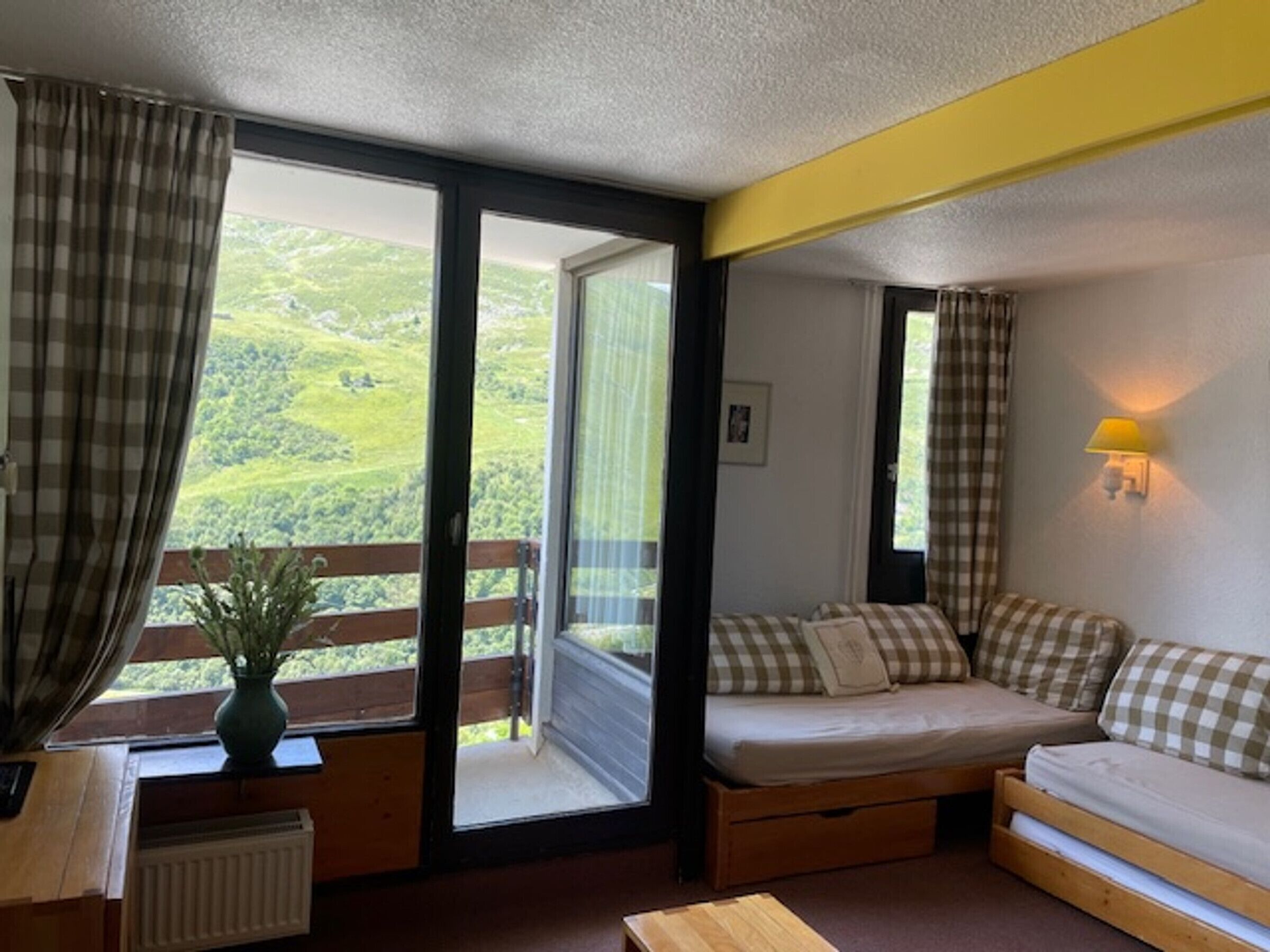Um quarto acolhedor com uma cama, uma mesa pequena e uma janela com cortinas.