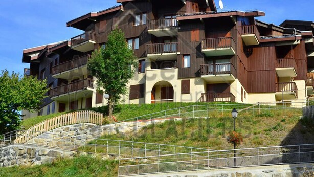 A multi-story hotel with balconies, a stone staircase, and a clear sky. - Duplex for 10, near slopes and center (La Plagne Montchavin Les Coches)