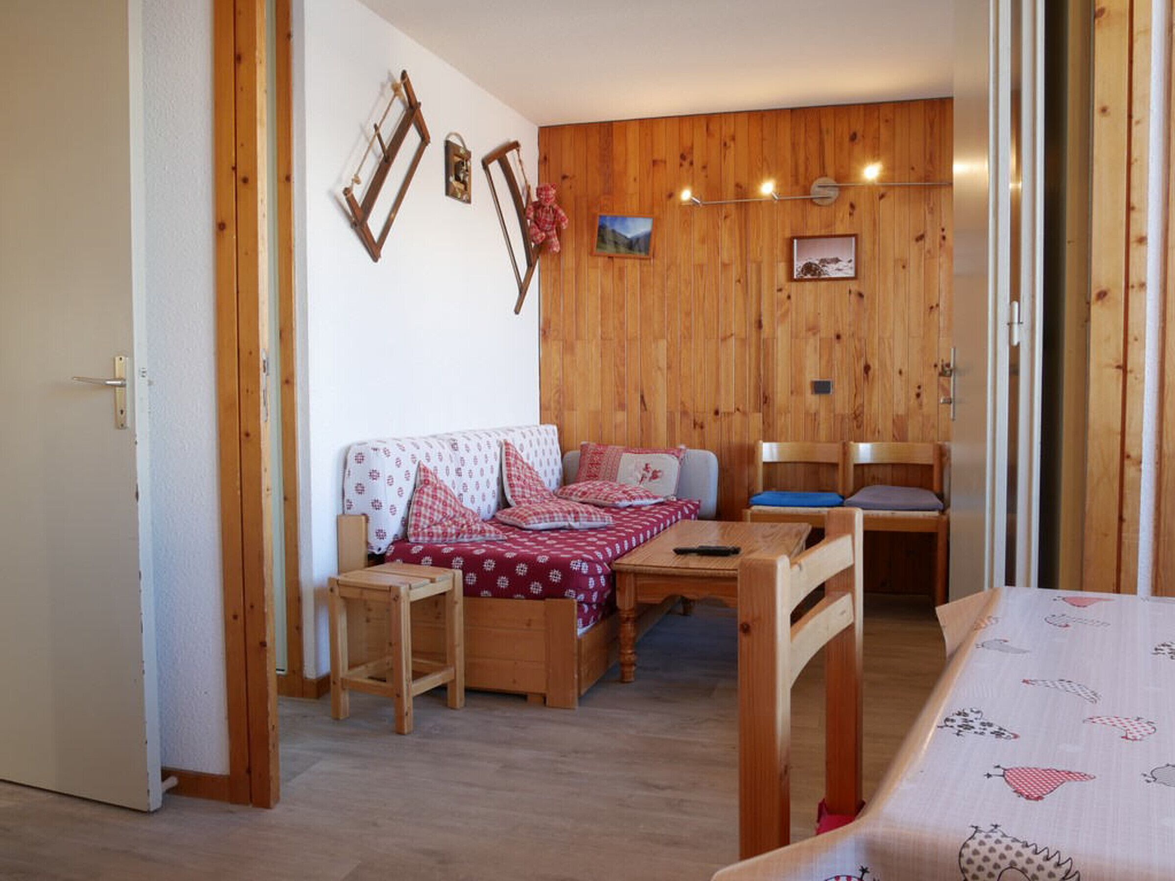 Ein gemütliches Zimmer mit einer Holzwand, einem Sofa, einem Tisch und einem Stuhl.