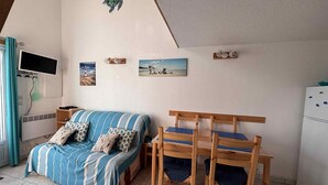 Ein gemütliches Schlafzimmer mit Bett, Schreibtisch und Stuhl. An den Wänden befinden sich Dekorationen und ein Fenster mit Vorhängen.