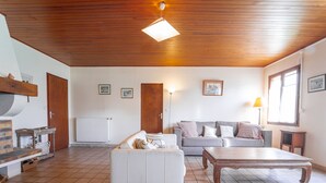 Un salon spacieux doté d’une cheminée, d’un canapé, d’une table basse et d’un plafond en bois.