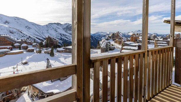 A wooden balcony overlooking a snow-covered mountain village with buildings and ski slopes. - New penthouse for 12, 4 balconies, Alpages 1, Avoriaz (Avoriaz)