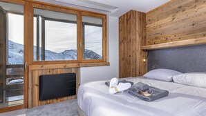 A bedroom with a bed, a wooden headboard, a large window with a view of mountains, and a television on the wall. - New penthouse for 12, 4 balconies, Alpages 1, Avoriaz (Avoriaz)