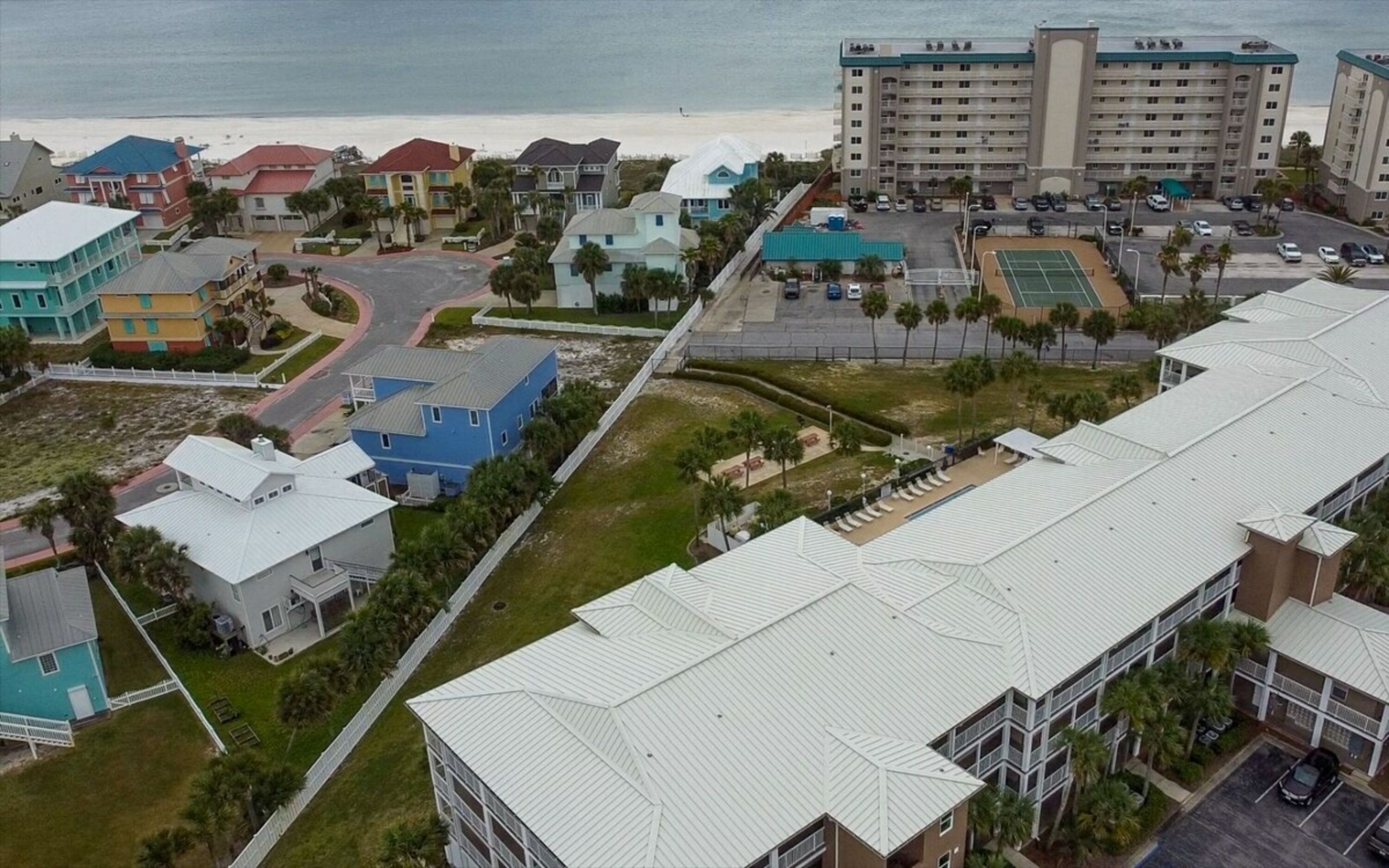 Ein Küstenhotel mit mehreren Gebäuden, Blick auf den Strand und einem Parkplatz.