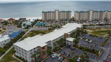 Um hotel com vários andares, estacionamento e vista para o oceano.