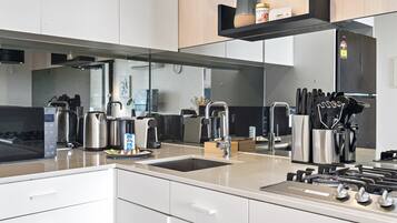A modern kitchen with stainless steel appliances, a built-in sink, and a knife block.