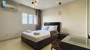 Une chambre d’hôtel moderne, équipée d’un lit, d’un bureau et d’une chaise.