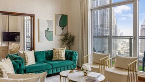 A modern living room with a green sofa, a flat-screen TV, and a large window offering a city view. - Durrani Homes - Alluring 5BR with Private Jacuzzi (Dubai)