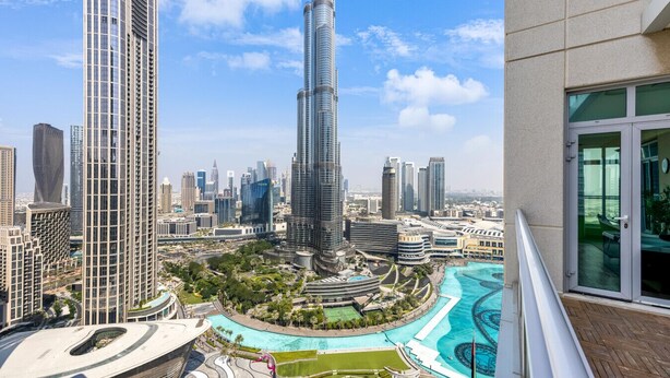 A high-rise building with a distinctive curved design, surrounded by other modern skyscrapers, a landscaped pool area, and a view of the cityscape. - Durrani Homes - Alluring 5BR with Private Jacuzzi (Dubai)