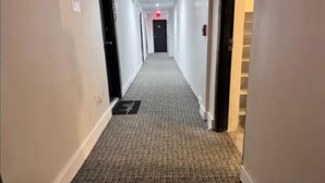 A hallway with carpeted floors and white walls. - Miami Studio Comfort Close to the Shore (Miami Beach)