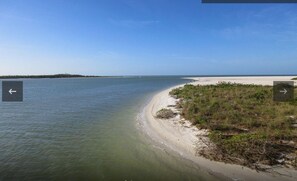 En strand vid kusten med klart vatten och en sandstrand.