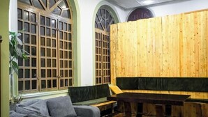 A room with a wooden partition, a sofa, a bench, and a table. - Flora Hostel Baku (Baku)