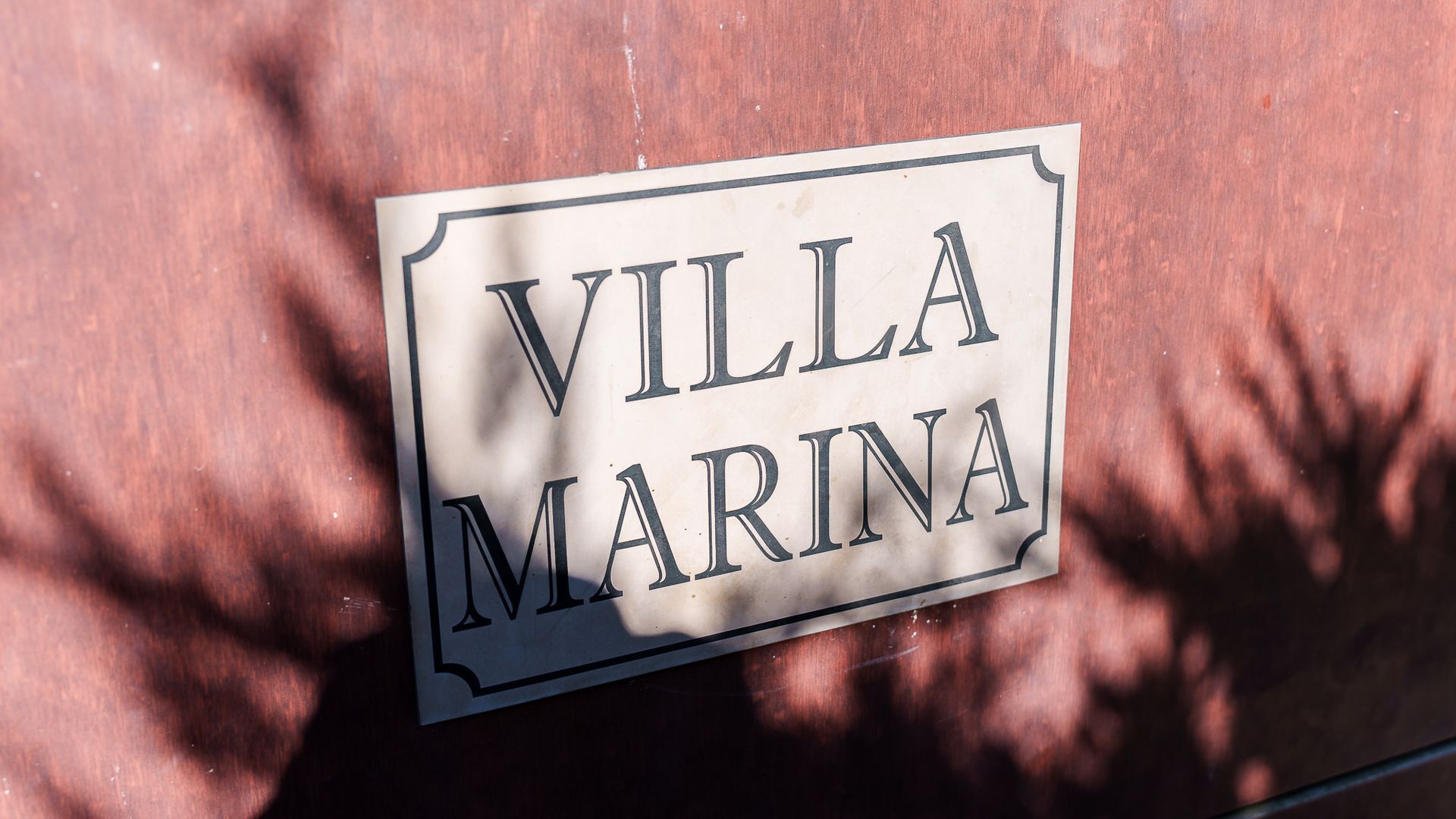 Un letrero con el texto 'VILLA MARINA' sobre una superficie de madera.