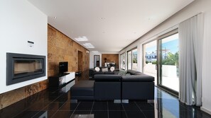 A modern living room with a fireplace, a sofa set, and a dining area. - Villa Marina Casa Luxuosa c/Piscina by LovelyStay (Ferragudo)