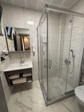Habitación económica | Baño | Regadera, secadora de cabello, pantuflas, toallas