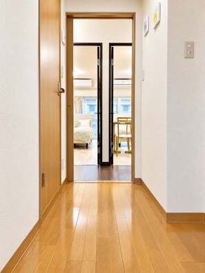 A hallway leading to a bedroom with a bed, a chair, and a window. - Minato-ku, Tokyo tourism, direct access to the airport, 2K, room with a view of Tokyo Tower (東京都港区高輪1−5−19)