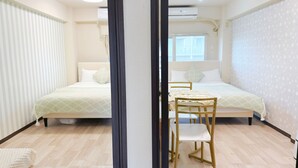 Une chambre moderne avec deux lits, une chaise en bois et une fenêtre.