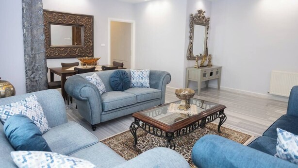 Un saló modern amb un sofà blau, una taula de centre i objectes decoratius.