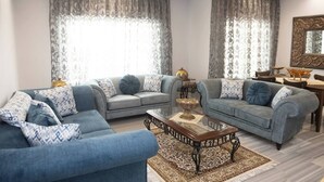 Un saló modern amb dos sofàs, una taula de centre i una zona de menjador amb taula i cadires.