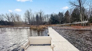 Een bankje langs een verhard pad aan een rivier.