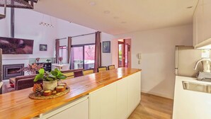 A modern kitchen with a wooden countertop, white cabinets, and a built-in oven. - RARE Designer Loft w/ Garden, Jacuzzi & Rooftop! (DAI)