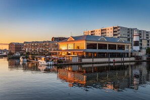 Ein Hotel am Wasser mit Essbereich, Schwimmbad und Blick auf das Wasser.