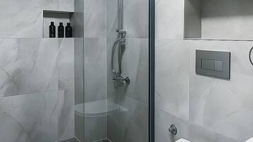 A modern bathroom with a glass-enclosed shower, a white toilet, and a built-in shelf with toiletries.