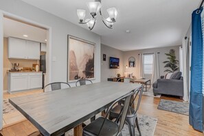 A modern living space with a dining area, kitchen, and seating area. - 5BR Group Home by the Olympic Center / Hot Tub, 2 Kitchens (Colorado Springs)