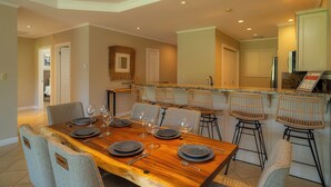 Un comedor con una mesa de madera dispuesta para seis personas, rodeada de sillas de mimbre.