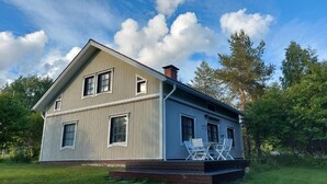 Une maison à deux étages avec un porche et une cheminée.