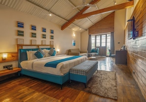 A bedroom with a large bed, a bench, a desk, and a chair. - The Mainland Resorts Kodaikanal (Kodaikanal)