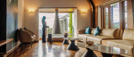 A spacious living area with a high ceiling, a large window, a sofa, and a statue.