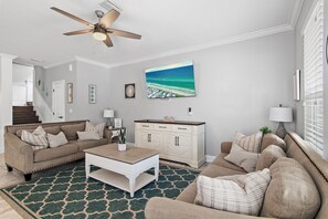 A living room with a beige sofa, a white coffee table, and a patterned rug. - Walk2Beach• HUGE Pool • Crystal Beach (Destin)