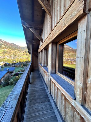 A wooden balcony with a view of a valley and mountains. - Chalet with view 10 minutes from Megève. (Praz-sur-Arly)