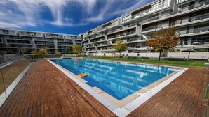 Un moderno edificio de apartamentos con piscina y terraza de madera.