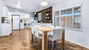 Eine moderne Küche mit weißen Schränken, einem Holzespeise Tisch und einem eingebauten Backofen.