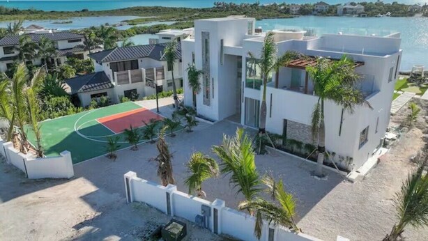 Um resort com arquitetura moderna, quadra de basquete e vista para o oceano.