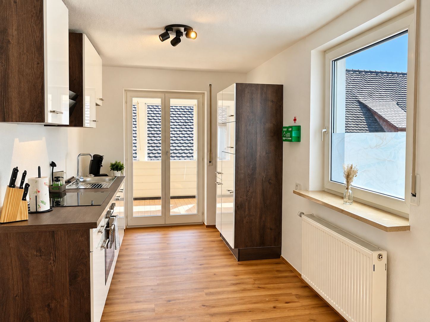 Cocina moderna con estufa integrada, pileta y ventana con vista a un paisaje nevado.