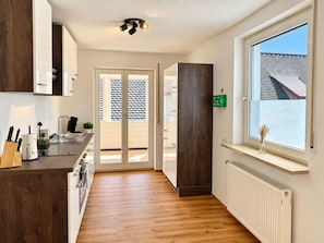 Cocina moderna con estufa integrada, pileta y ventana con vista a un paisaje nevado.
