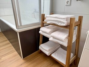 A wooden shelf with neatly folded white towels in a bathroom. - Apartment StadtUfer - Top location & close to the lake (Friedrichshafen)
