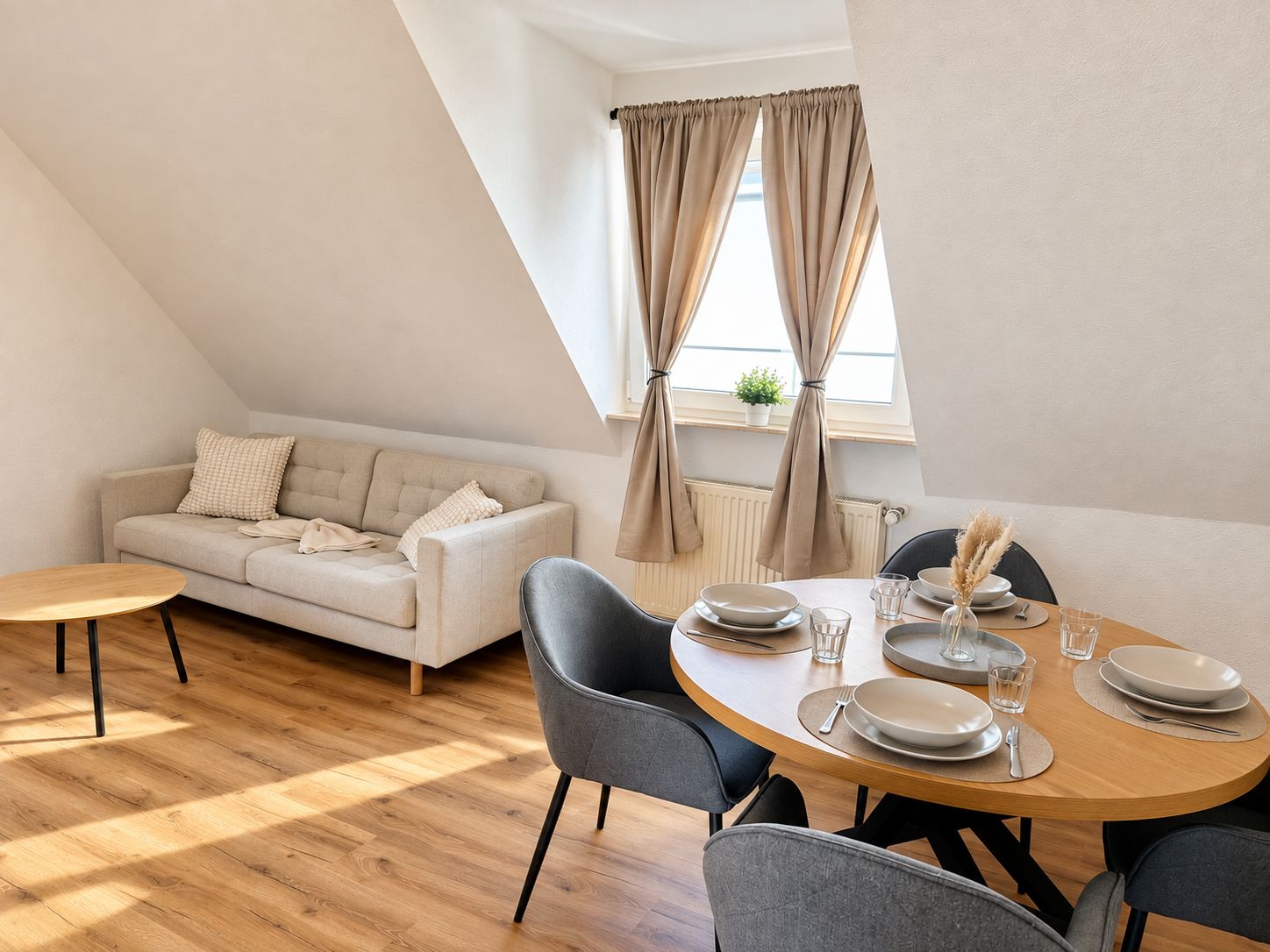 Une chambre de style loft moderne, comprenant un coin repas avec un canapé, une table de salle à manger ronde et une fenêtre avec des rideaux.