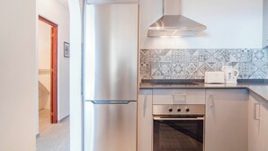 Una cucina moderna con elettrodomestici in acciaio inossidabile, uno schienale decorato e un tostapane sul piano di lavoro.