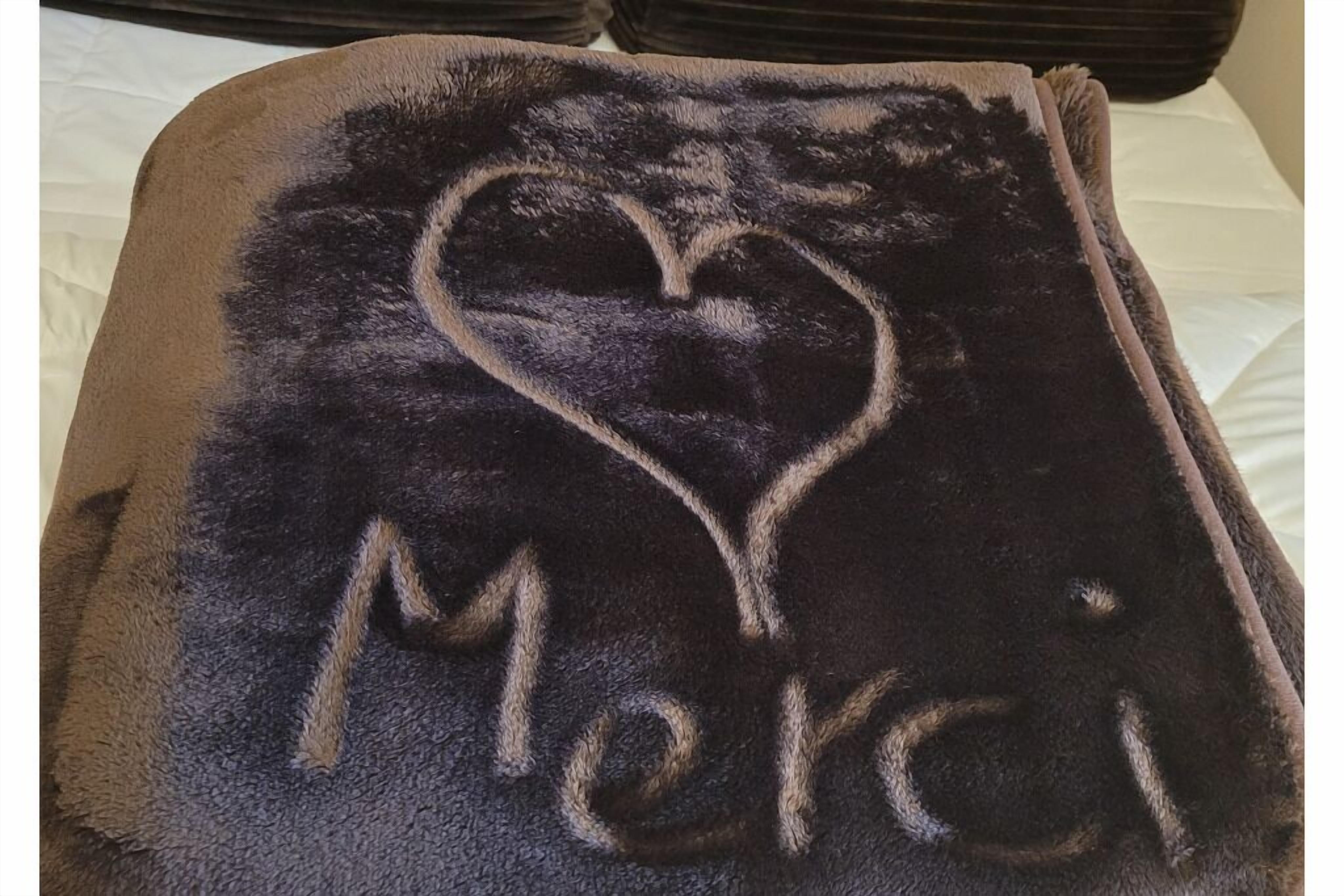 Une couverture ornée d’un cœur et du mot « Merci » brodé dessus.