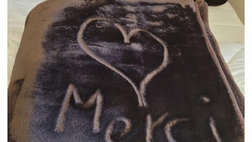 Une couverture ornée d’un cœur et du mot « Merci » brodé dessus.